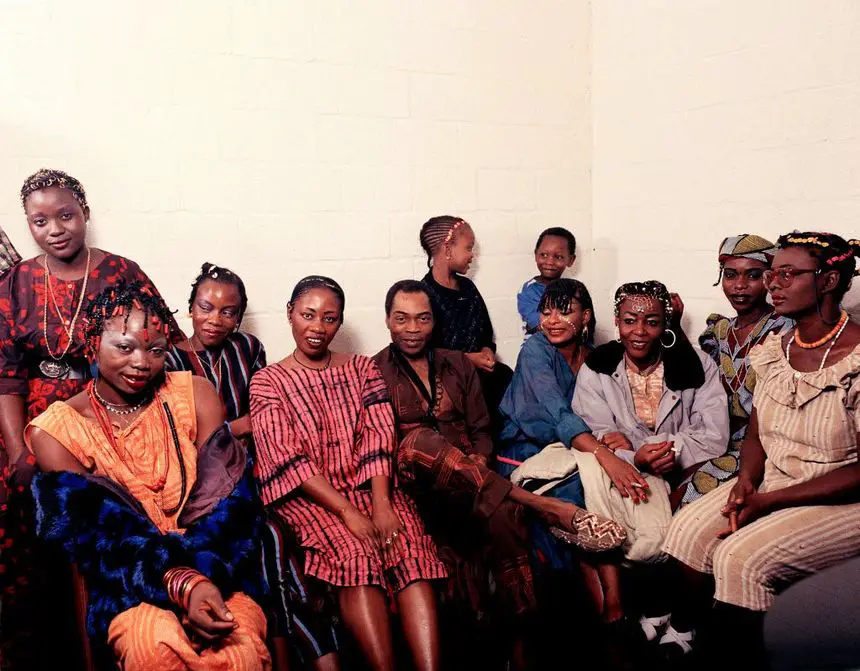 Fela Kuti with his wives, dancers and some children backstage at the Théâtre National de la Forêt in Brussels (Belgium, 1981)