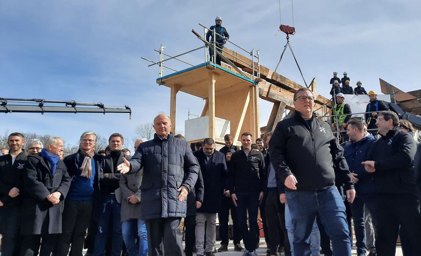 At the end of the assembly of the stool, General Jean-Louis Georgelin, president of the public establishment Rebuilding Notre-Dame de Paris - right hand raised - with the chief architects and the carpenters responsible for the work of restoring the boom frame.