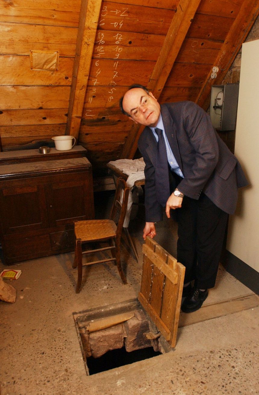 Canon Alain Donius shows the entrance to the secret passage through which the Mont St Odile thief entered the library (27.05.2002)